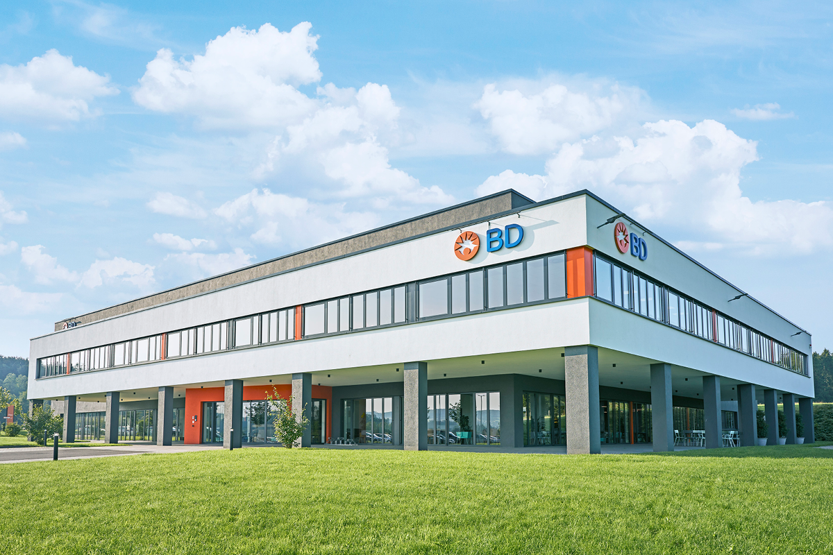 BD Rowa Firmengebäude mit modernem Architekturdesign in grüner Umgebung – Standort für Entwicklung und Produktion pharmazeutischer Automatisierungslösungen.