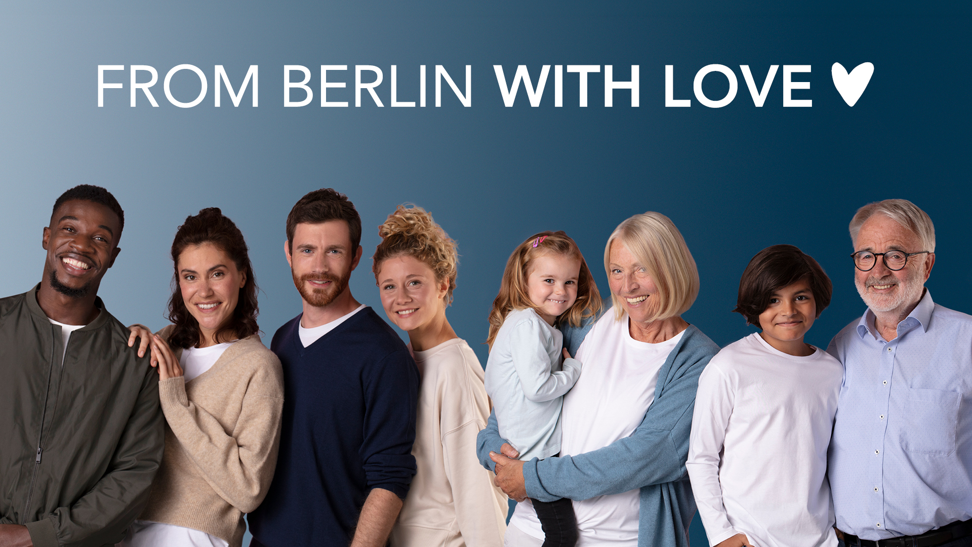 Gruppenporträt von acht lächelnden Menschen unterschiedlichen Alters, die nebeneinander vor einem blau verlaufenden Hintergrund stehen. Eine ältere Frau hält ein kleines Mädchen auf dem Arm. Oben im Bild steht der Schriftzug ‚FROM BERLIN WITH LOVE“.